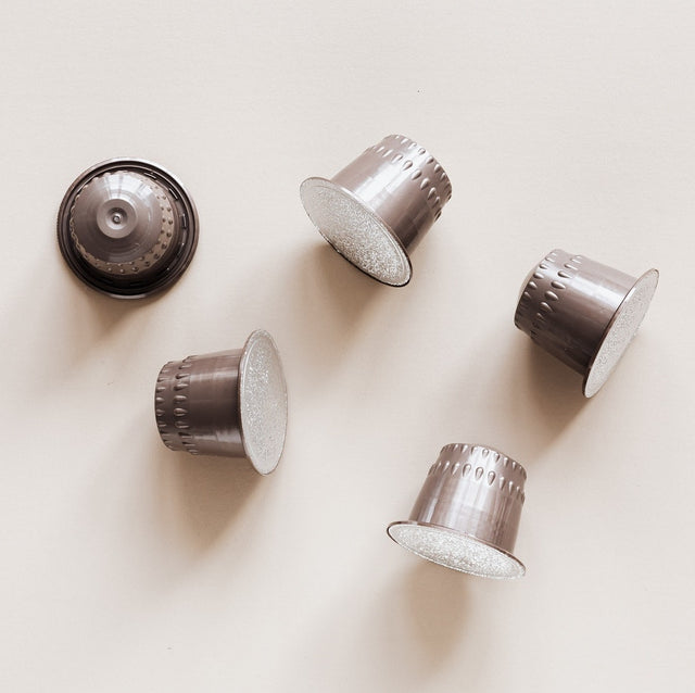 Stock image of coffee pods scattered on a white background