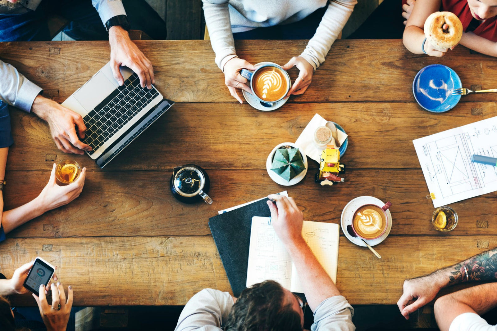 People gathered around a office roundtable with coffee in hand