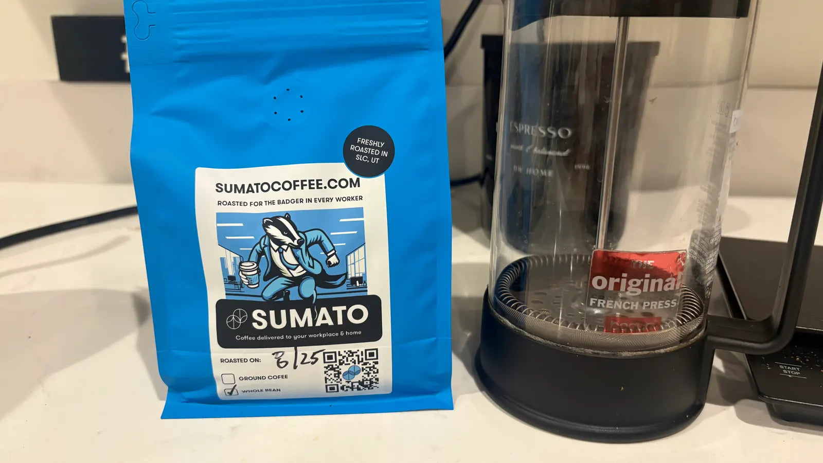 Freshly roasted Sumato Coffee beside a simple French press brewing setup