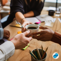 Coworkers sharing Culture Hire Sumato coffee during a collaborative team meeting