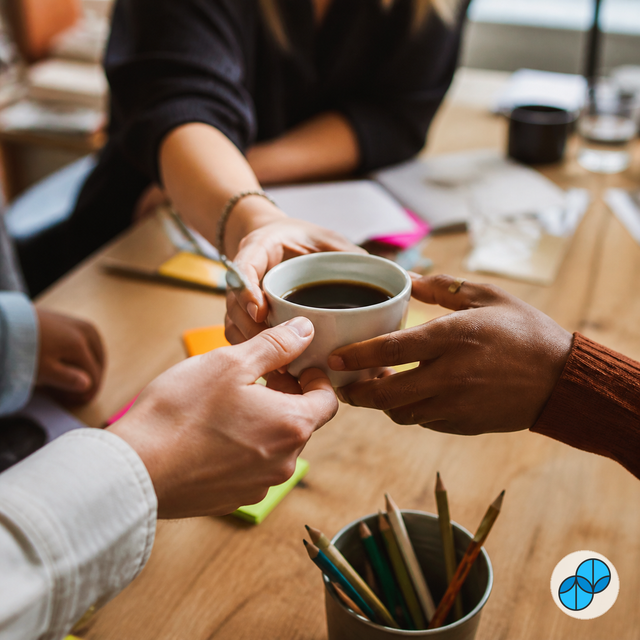 Coworkers sharing Culture Hire Sumato coffee during a collaborative team meeting