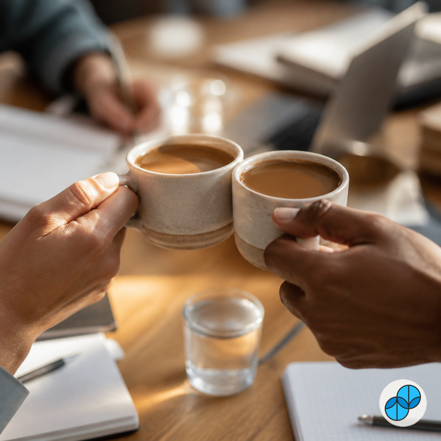 Coworkers sharing cups of Sumato coffee during a Touch Base meeting